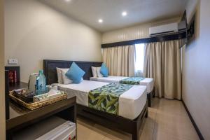 ein Hotelzimmer mit zwei Betten und einem Fenster in der Unterkunft Fiji Gateway Hotel in Nadi