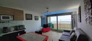 a living room with a couch and a large window at Le Grand Large in Berck-sur-Mer