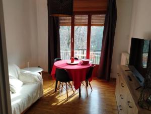 a room with a table with a red table cloth on it at Central near station in Bardonecchia