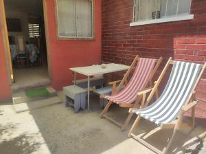 dos sillas y una mesa junto a una pared de ladrillo en Alojamiento Miguel y Lily, en El Tabo