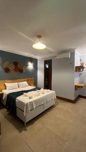 a bedroom with a large bed in a room at Pousada Recreio Casa Grande in Cascavel