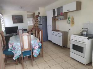 a kitchen with a table and a kitchen with a stove at Alojamiento Miguel y Lily in El Tabo