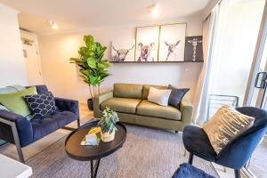 a living room with a couch and chairs at Bright 1BR with On-Site Gym I Sauna I Pool and Parking in Sydney