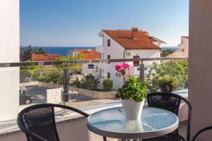 a table with a vase with a flower on a balcony at Apartments Stella in Krk
