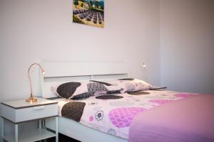 a bedroom with a bed and a desk with a lamp at Apartments Stella in Krk