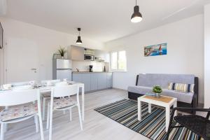 a kitchen and living room with a table and a couch at Apartments Stella in Krk