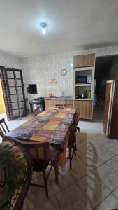 a kitchen with a table with chairs and a kitchen with a tableablish at Cantinho das Marias in Itapoa