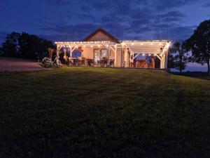 a house with a pergola on a lawn at night at Domek Mikołajki in Mikołajki