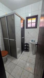a bathroom with a shower and a toilet and a sink at Cantinho das Marias in Itapoa