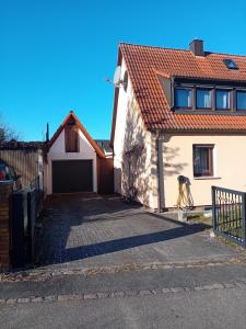 a house with a driveway and a garage at Business und Messe Apartment TULPE in Zirndorf