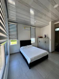 una camera da letto con un letto grande in una stanza con finestre di Increible lugar de desconexion a Nariño