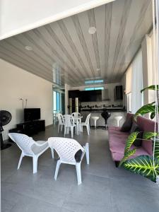 un soggiorno con sedie bianche e un divano di Increible lugar de desconexion a Nariño