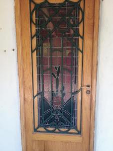 a wooden door with a window with a flower on it at Ñanderoga in San Marcos Sierras