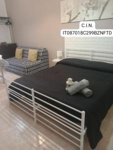 a bed with a black blanket and a chair in a room at Casa vacanza Contry House Romantic in Grammichele