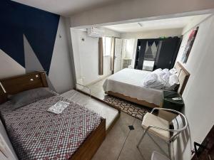 a small bedroom with two beds and a chair at Casa na Frente da Praia do Maçarico in Salinópolis +46 photos