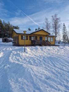 a yellow house in the snow in front at Säbytorp in Kil