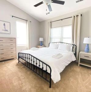 a bedroom with a large white bed with a ceiling fan at Sojourn The Lighthouse Beach Front Resort Villa in North Camellia Acres