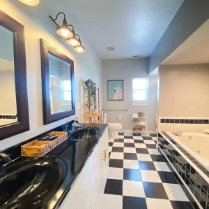 a bathroom with two sinks and a black and white checkered floor at Sojourn The Lighthouse Beach Front Resort Villa in North Camellia Acres +25 photos