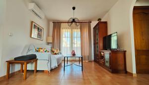 a living room with a couch and a tv at Apartamento ideal a un paso de la playa in Playas de Vera