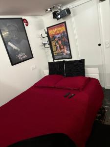 a bed with a red comforter in a bedroom at Cabanon aux films in Saint-Brieuc +10 photos