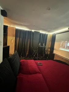 a bedroom with a red bed with a table in the background at Cabanon aux films in Saint-Brieuc