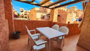 a white table and chairs on a balcony with buildings at Apartamento ideal a un paso de la playa in Playas de Vera