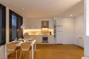 a kitchen with a table and chairs in a room at Urbanfive apartamentos Ourense centro in Ourense