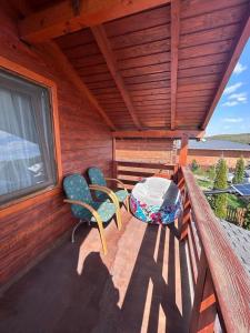 a porch with two chairs and a table and a window at Cabana Irina Băile Figa in Beclean +9 photos