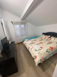 a bedroom with a bed with a comforter on it at Cabana Irina Băile Figa in Beclean