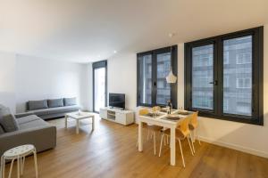a living room with a table and a couch at Urbanfive apartamentos Ourense centro in Ourense