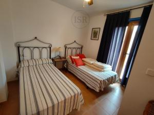 a bedroom with two beds and a window at Apartamento ideal a un paso de la playa in Playas de Vera +17 photos
