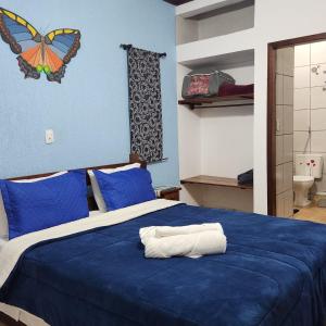a bedroom with a blue bed with a butterfly on the wall at Sitio Cheiro de Mato in Monte Alegre do Sul