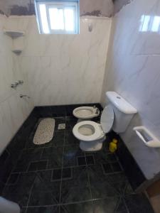 Un baño con inodoro blanco y ventana. en Casablanca, en La Adela 3 fotos más