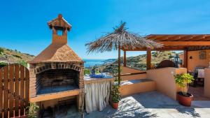 a outdoor pizza oven with a view of the ocean at Gonzalez Almuñécar by Ruralidays in Almuñécar