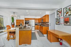 a kitchen with wooden cabinets and a large kitchen island at Sanctuary-5BR Home for Extended Stays & Family Comfort in Spokane +22 photos