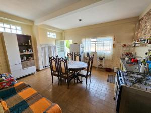 a kitchen with a table and chairs and a stove at Atalho Guest House in Cunha