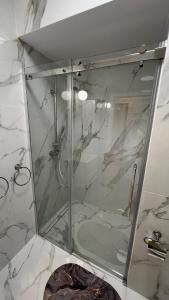 a shower with a glass door in a bathroom at Fordon GOLD 30 z ogródkiem in Bydgoszcz