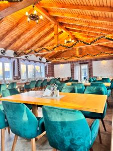 a dining room with a wooden table and green chairs at Royal Alpin Crown in Cavnic