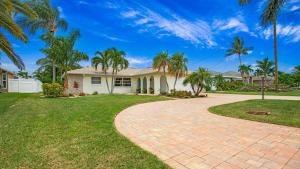ein Haus mit Palmen und einer Ziegelsteinfahrt in der Unterkunft 5 Star Experience, Heated Pool close to Everything in Cape Coral