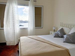 ein Schlafzimmer mit einem Bett und einem großen Fenster in der Unterkunft Villa Irene in Funchal + 19 Fotos