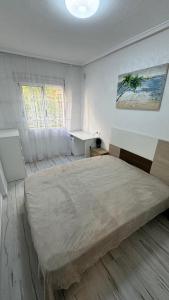 ein Schlafzimmer mit großem Bett und Fenster in der Unterkunft Playa del Cura apartment with 2 bedrooms in Torrevieja