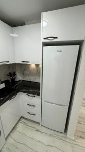 eine Küche mit weißen Schränken und einem Kühlschrank in der Unterkunft Playa del Cura apartment with 2 bedrooms in Torrevieja
