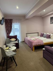 a hotel room with a bed and a couch at Apart Hotel Avinos in Lviv