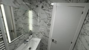 ein weißes Badezimmer mit Waschbecken und Spiegel in der Unterkunft Playa del Cura apartment with 2 bedrooms in Torrevieja + 16 Fotos