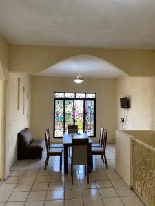 une salle à manger avec une table et des chaises et une fenêtre dans l'établissement Bonita casa grande en la mejor ubicación de cunduacan, à Cunduacán