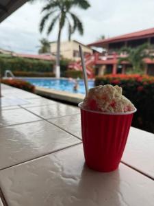 a drink in a red cup sitting on a table at Hotel La Roca del Mar in Puntarenas