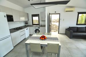 Una cocina con una mesa con un bol de fruta encima. en Villa Sotavento Ocean Views Modern New Apartment in Natural Park, en Playa de Jandía 13 fotos más