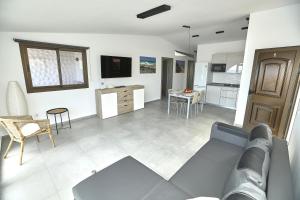 Una sala de estar con un sofá y una cocina. en Villa Sotavento Ocean Views Modern New Apartment in Natural Park, en Playa de Jandía