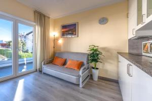 a living room with a couch and a large window at Gold Coast Photography Inn in Estoril