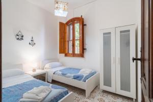 a bedroom with two beds and a window at Villa Melisa in Fontane Bianche